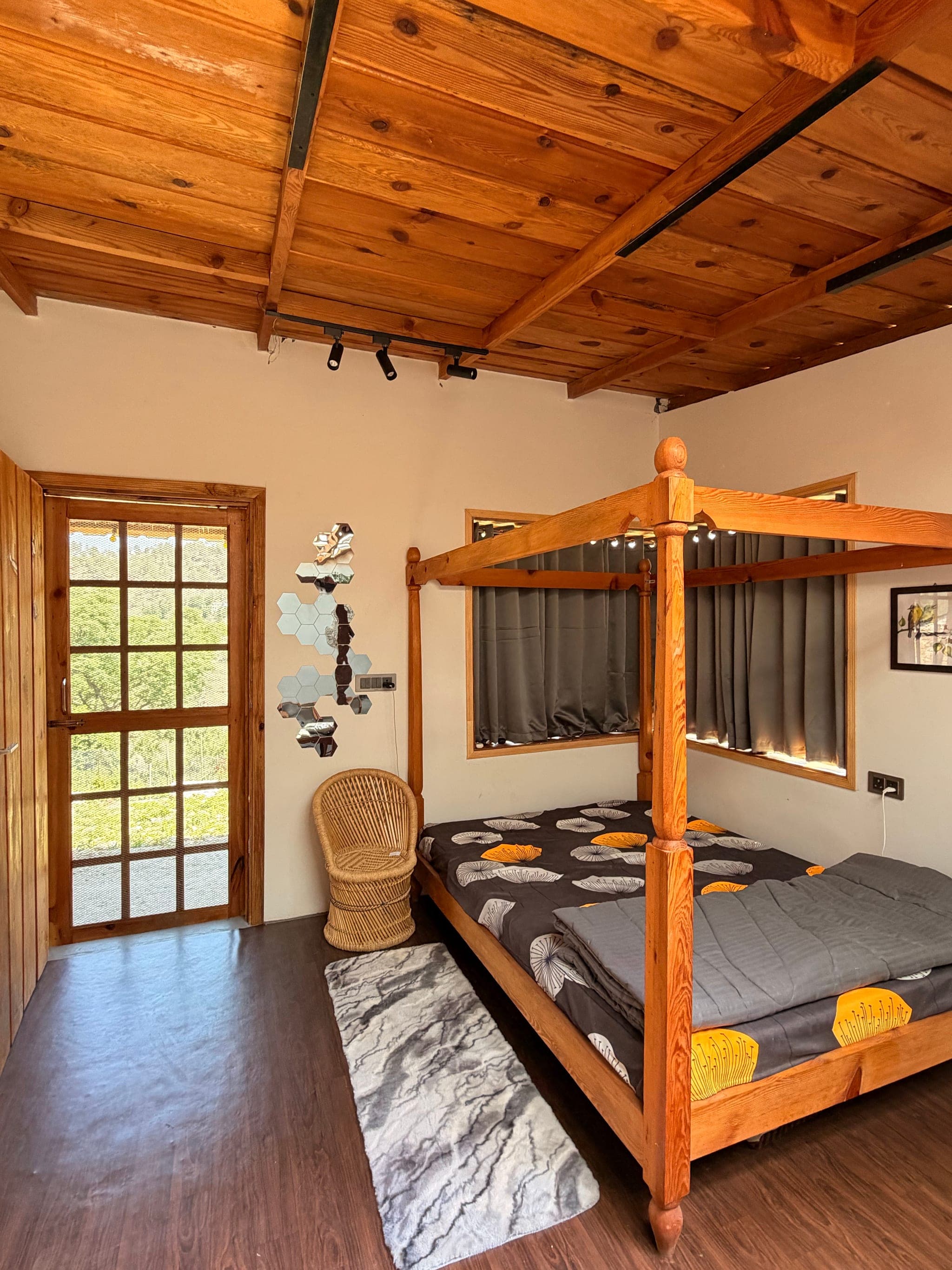 Guest room with a wooden four-poster bed and timber ceiling at The Vintage Kumaon, Almora